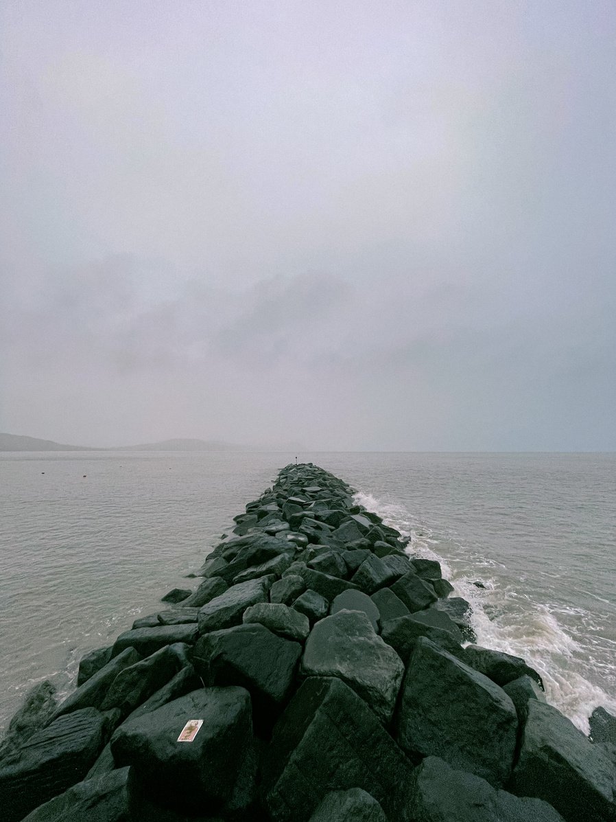 Gray Rocks on Sea Under White Sky